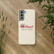 A iHeartFruitBox Biodegradable Phone Case showcasing vibrant images of Organically Grown fruits from Printify, placed on a rustic wood surface for an earthy touch.