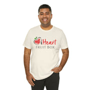 A man wearing an iHeartFruitBox Fitted Unisex T-Shirt by Printify, promoting organically grown tropical fruit.