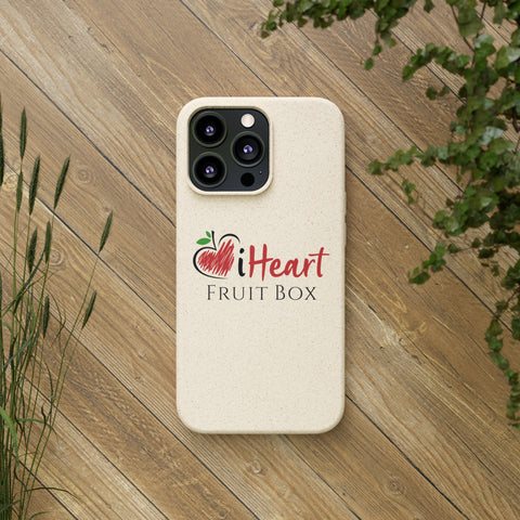 An iHeartFruitBox Biodegradable phone case featuring a Tropical Fruit design, displayed on a wood surface. (Printify)