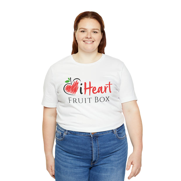 A woman wearing a white iHeartFruitBox Fitted Unisex T-Shirt made by Printify, demonstrating her love and support for organically grown tropical fruit.