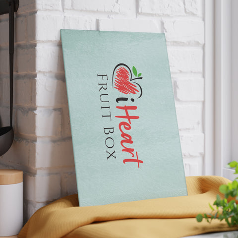A iHeartFruitBox Glass Cutting Board with the word heart on it sitting on a brick wall, promoting Organically Grown Tropical Fruit, made by Printify.