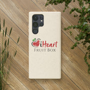 A white iHeartFruitBox Biodegradable Phone Case on a wood surface with a Printify sticker.