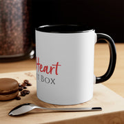 An iHeartFruitBox Coffee Mug, 11oz by Printify with organically grown beans on a cutting board.