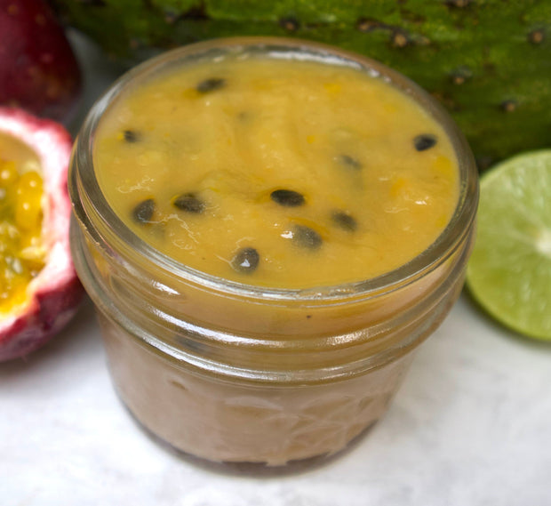 The Soursop Passion Preserve by iHeartFruitBox is a vibrant yellow tropical fruit spread, surrounded by fresh passion fruit and lime—perfect for zero-waste jam enthusiasts.