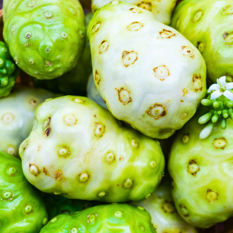 A bunch of Noni fruits with white spots on them, available through iHeartFruitBox.